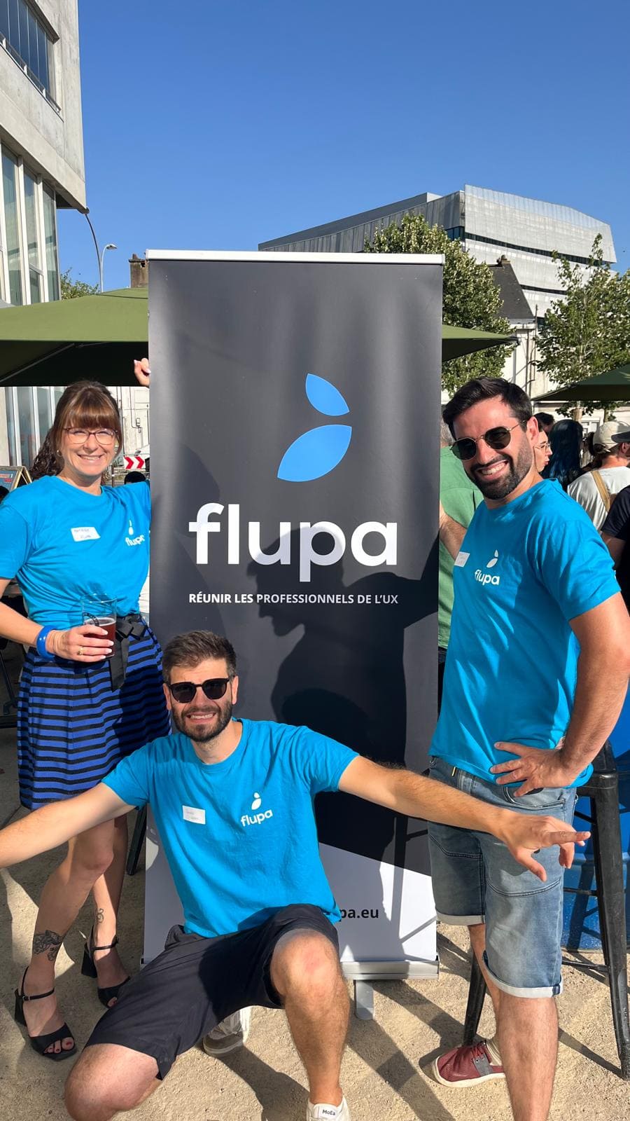 Quentin avec Mathilde et Pierre devant le kakémono Flupa, en T-shirts bleus, lors d'un événement Flupa Nantes