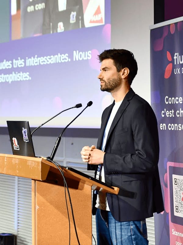 Quentin Ledoux au pupitre, pendant une intervention aux Flupa UX Days 2026.